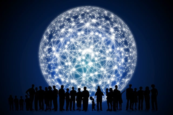 Shadows of people looking at a lit-up networked sphere.